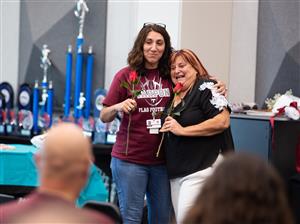 Deidre Deal receives a rose from a former student